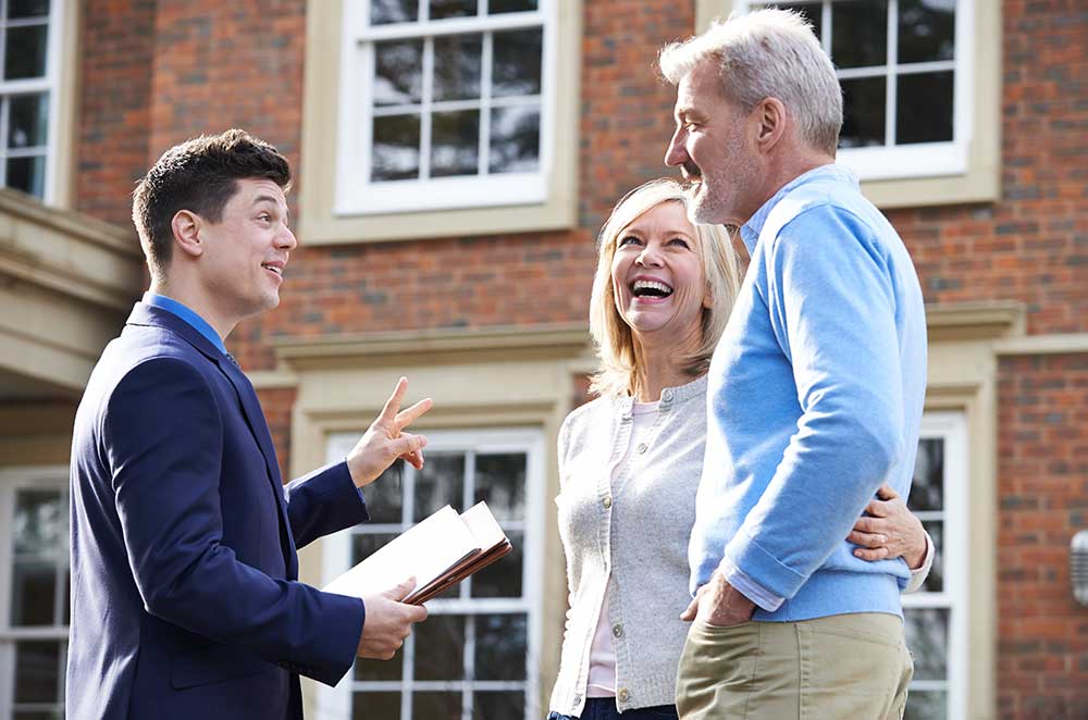 Happy Couple with Agent — Property Valuation in Caloundra, QLD Happy Couple with Agent — Property Valuation in Caloundra, QLD