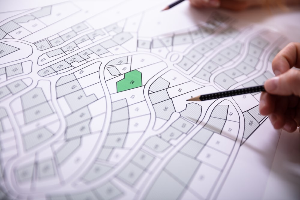 A land valuer is looking at the plan of a street on the Sunshine Coast before performing land valuation
